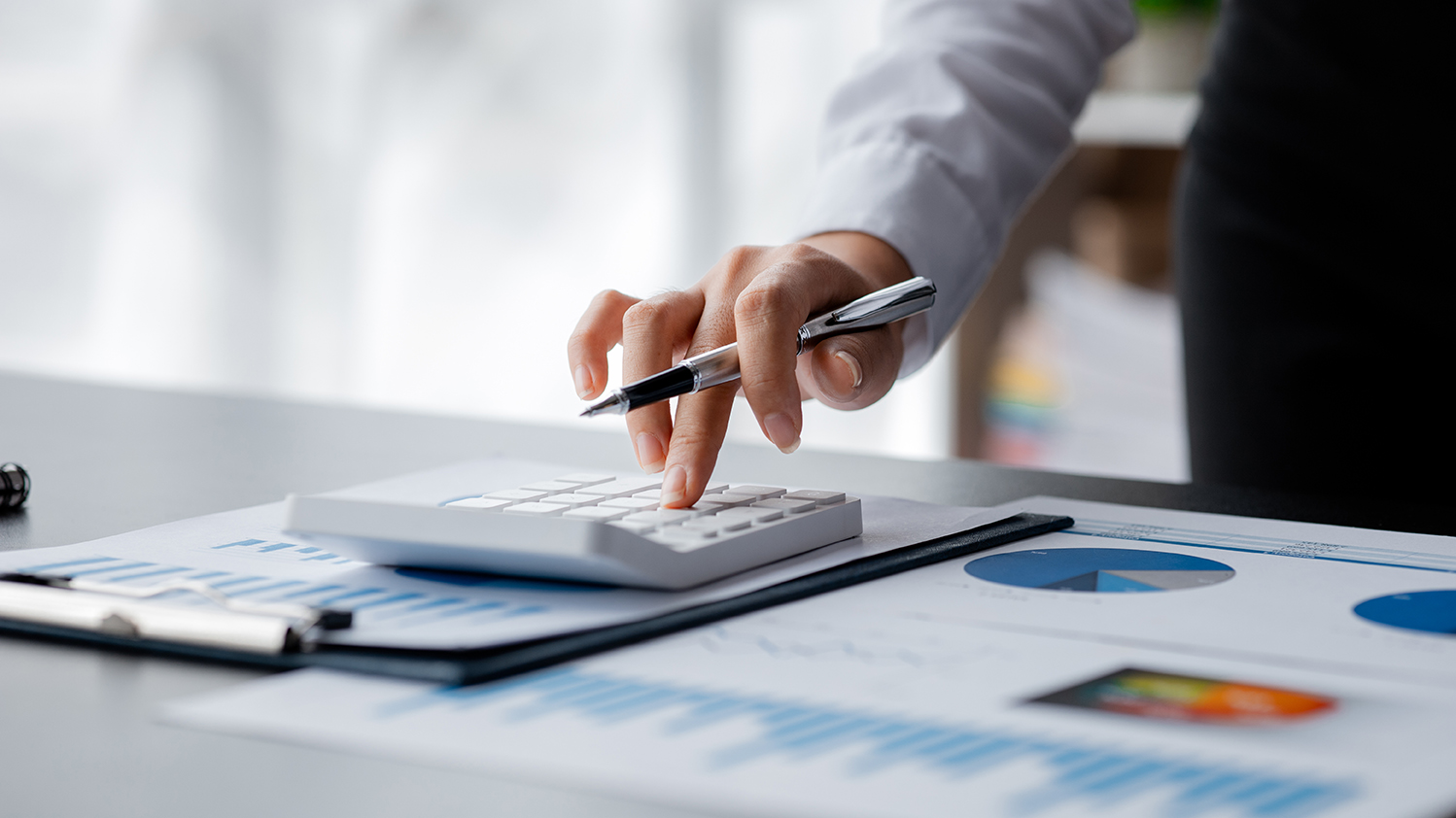 Businessman using a calculator to calculate numbers on a company